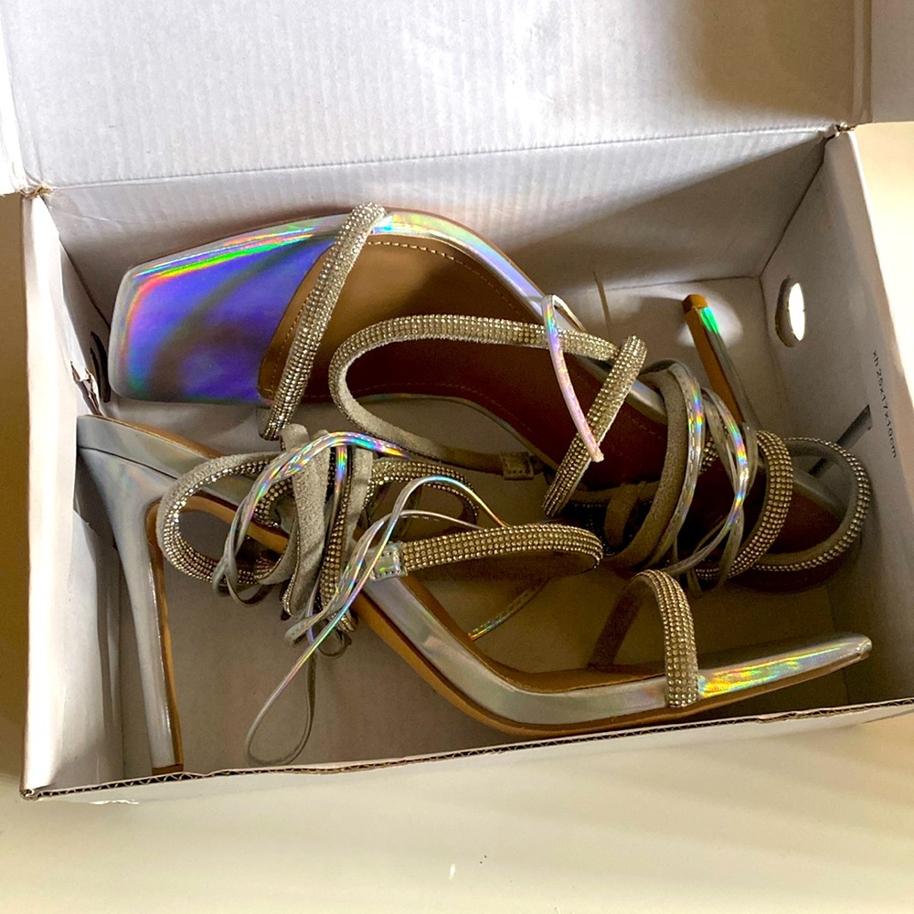 silver heels, straps that wrap around leg, has sliver blind throughout straps.